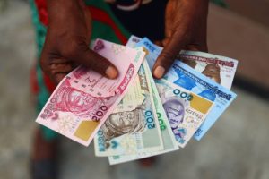 Hands holding the Old and New  Nigerian Naira Notes